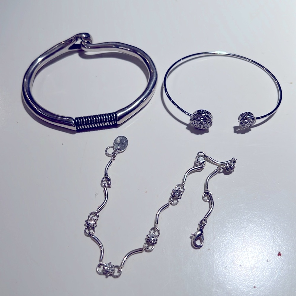 Three Silvertone assorted bracelets